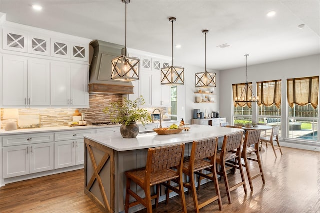 1741 Mountain Creek Ln, Prosper, TX 75078 - kitchen featuring tasteful backsplash, custom range hood, a kitchen bar, light countertops, and recessed lighting