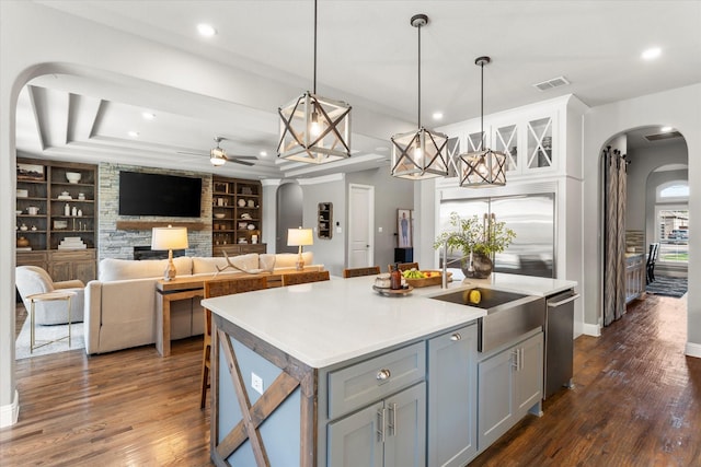 1741 Mountain Creek Ln, Prosper, TX 75078 - kitchen with arched walkways, a ceiling fan, gray cabinetry, built in shelves, and a sink