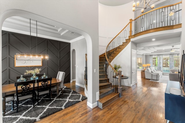 1741 Mountain Creek Ln, Prosper, TX 75078 - dining area featuring arched walkways, baseboards, wood finished floors, stairway, and a high ceiling