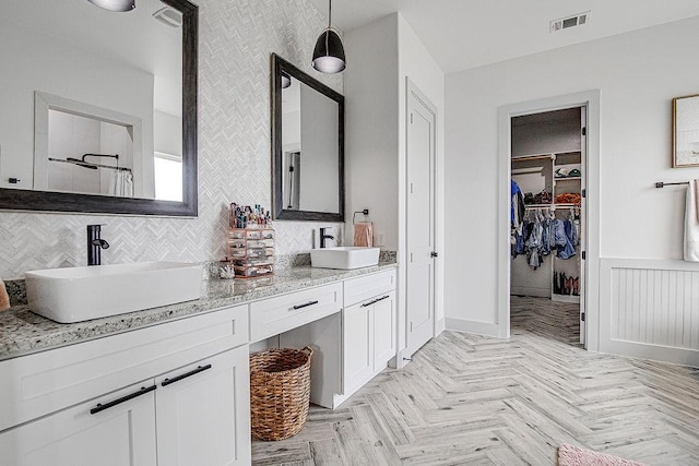 7336 Saint Augustine Dr, Cleburne, TX 76033 - bathroom featuring double vanity, a walk in closet, a shower, and a wainscoted wall