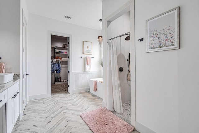 7336 Saint Augustine Dr, Cleburne, TX 76033 - full bathroom with a tile shower, vanity, a spacious closet, and a wainscoted wall