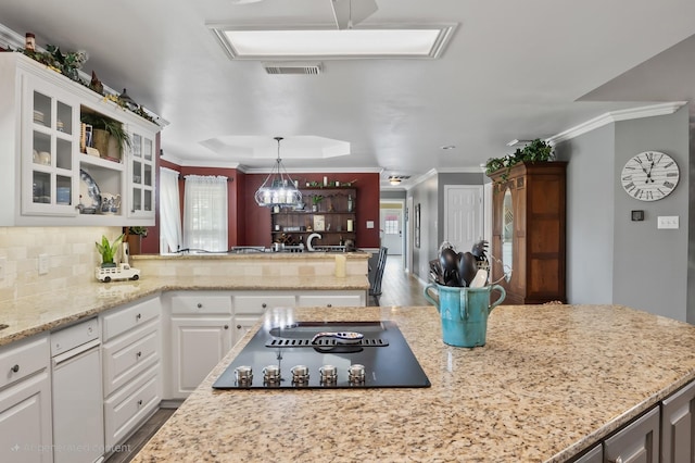10595 Gregory Rd, Sanger, TX 76266 - kitchen featuring black electric stovetop, glass insert cabinets, white cabinets, decorative backsplash, and crown molding