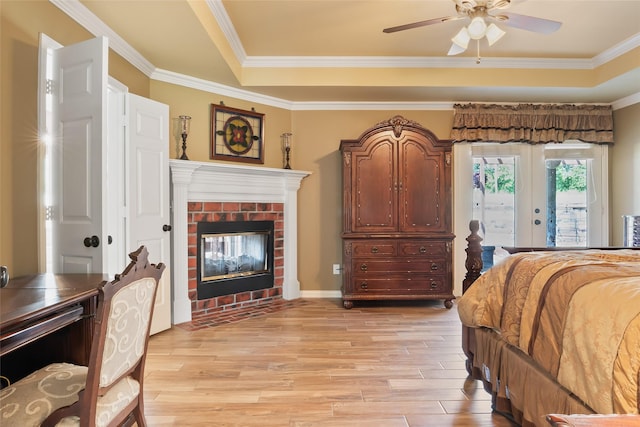 10595 Gregory Rd, Sanger, TX 76266 - bedroom featuring light wood finished floors, french doors, ornamental molding, a brick fireplace, and a raised ceiling