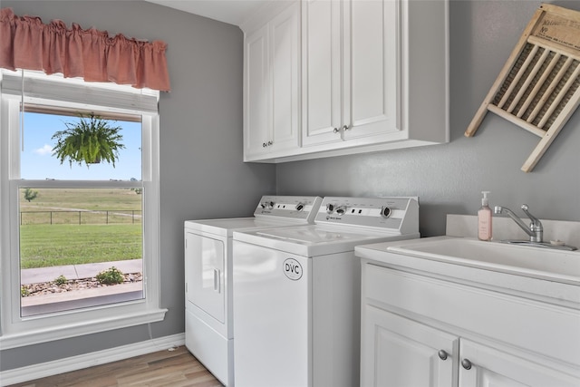 10595 Gregory Rd, Sanger, TX 76266 - laundry area featuring independent washer and dryer, cabinet space, and light wood-type flooring