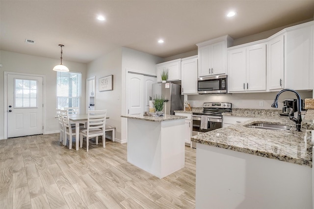 3108 Ridgecrest Dr, Granbury, TX 76048 - kitchen with appliances with stainless steel finishes, a sink, a center island, recessed lighting, and white cabinets