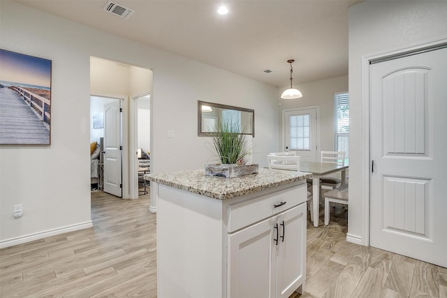 3108 Ridgecrest Dr, Granbury, TX 76048 - kitchen with white cabinets, a center island, pendant lighting, light stone countertops, and light wood-style floors