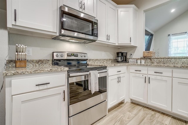 3108 Ridgecrest Dr, Granbury, TX 76048 - kitchen with appliances with stainless steel finishes, lofted ceiling, white cabinetry, and light stone counters