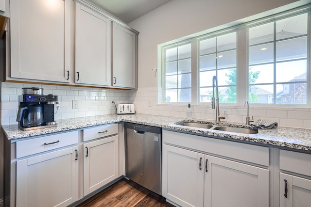 2246 Hartley Dr, Forney, TX 75126 - kitchen with stainless steel dishwasher, a sink, tasteful backsplash, dark wood-style flooring, and light stone counters