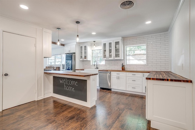 5712 Trail Lake Dr, Fort Worth, TX 76133 - kitchen featuring wooden counters, stainless steel appliances, a peninsula, glass insert cabinets, and tasteful backsplash