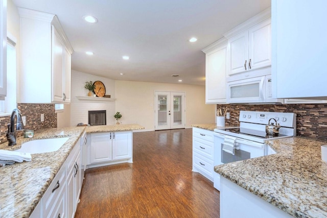 2489 Campus Ct, Abilene, TX 79601 - kitchen with white appliances, a sink, dark wood-style floors, a peninsula, and white cabinets