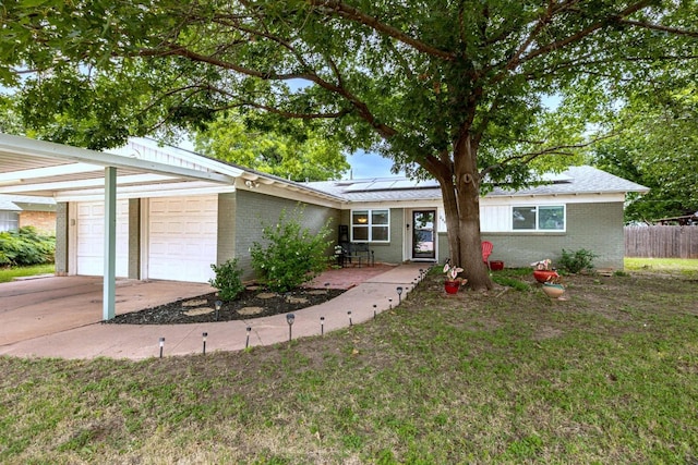 2489 Campus Ct, Abilene, TX 79601 - ranch-style house with brick siding, solar panels, and driveway