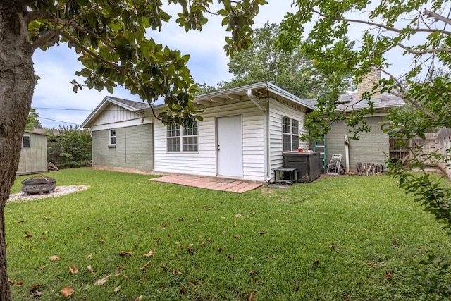 2489 Campus Ct, Abilene, TX 79601 - rear view of house featuring brick siding, a fire pit, a lawn, and a chimney