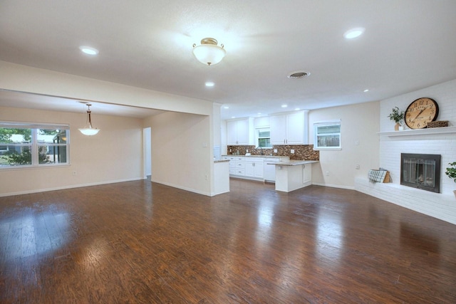 2489 Campus Ct, Abilene, TX 79601 - unfurnished living room featuring a fireplace, baseboards, dark wood finished floors, and recessed lighting