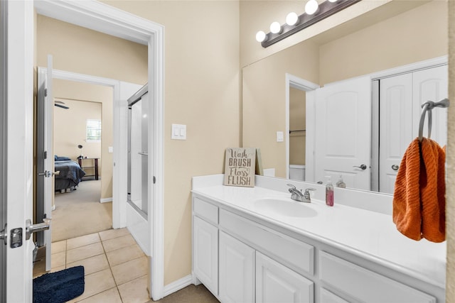1050 Crystal Falls Dr, Prosper, TX 75078 - ensuite bathroom with vanity, tile patterned flooring, baseboards, and combined bath / shower with glass door