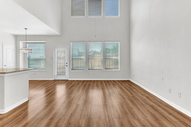 3724 Sicily St, Irving, TX 75038 - unfurnished living room with baseboards, wood finished floors, and a high ceiling