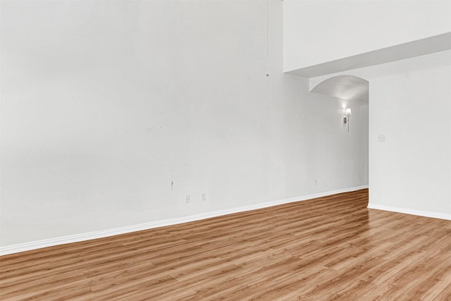 3724 Sicily St, Irving, TX 75038 - unfurnished room featuring light wood finished floors, arched walkways, and baseboards