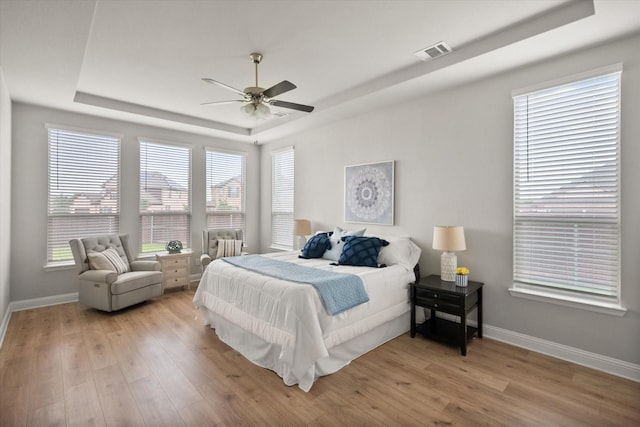 3604 Hidden Hollow Dr, Grand Prairie, TX 76065 - bedroom with a raised ceiling, baseboards, and light wood-style flooring