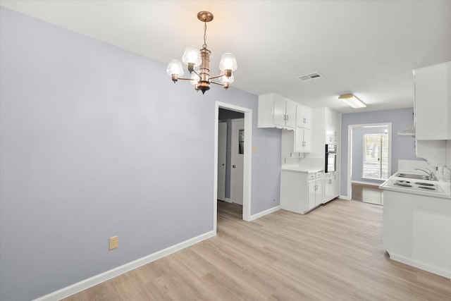 209 Circle Dr, Alvarado, TX 76009 - kitchen featuring extractor fan, a chandelier, light wood finished floors, baseboards, and light countertops