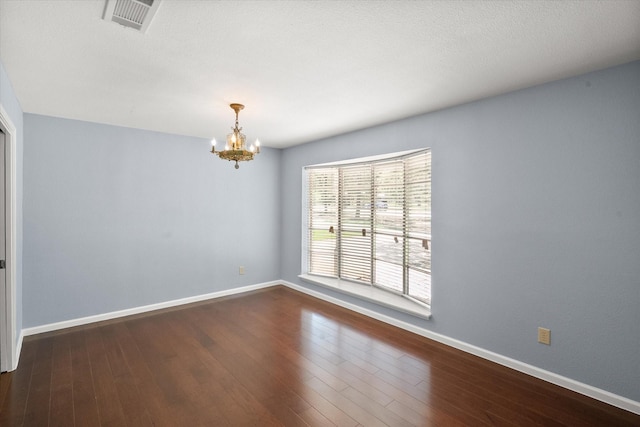 209 Circle Dr, Alvarado, TX 76009 - spare room with a chandelier, baseboards, and dark wood-type flooring