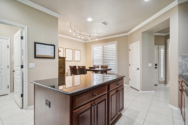 6173 Arcadia Park Ln, Frisco, TX 75036 - kitchen featuring ornamental molding, light tile patterned floors, dark stone counters, baseboards, and a kitchen island