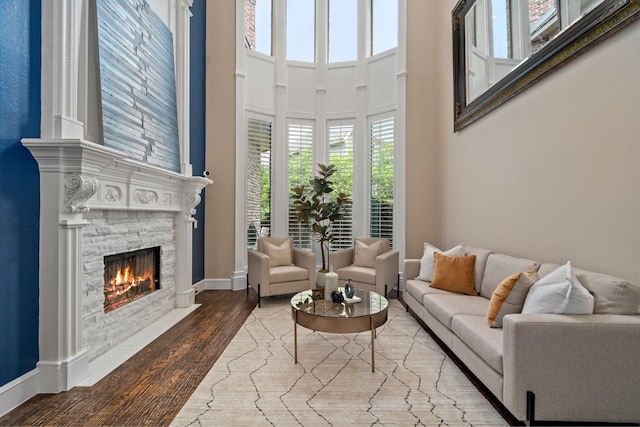 4452 Druid Hills Dr, Frisco, TX 75034 - living area with a stone fireplace, wood finished floors, baseboards, and a towering ceiling