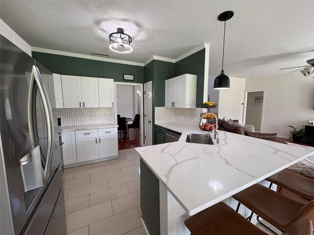702 John Thomas Dr, Keene, TX 76059 - kitchen featuring freestanding refrigerator, a sink, a peninsula, backsplash, and a breakfast bar