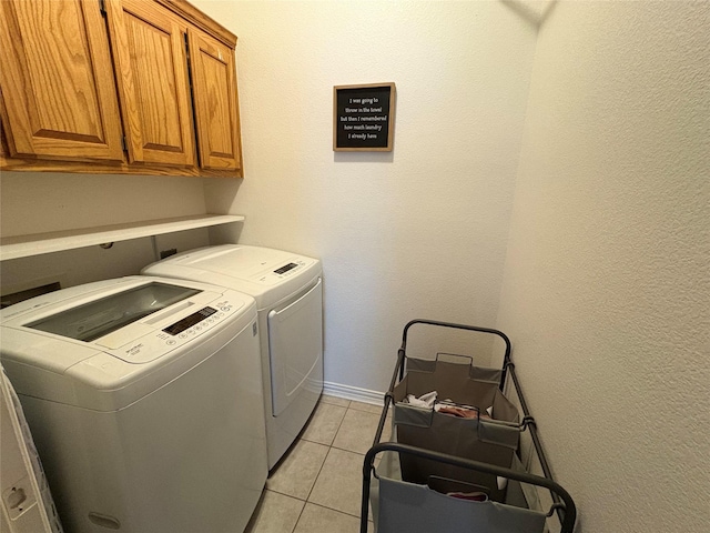 702 John Thomas Dr, Keene, TX 76059 - laundry area with cabinet space, washing machine and clothes dryer, light tile patterned flooring, and baseboards