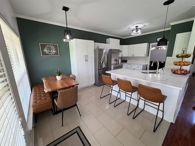 702 John Thomas Dr, Keene, TX 76059 - kitchen with stainless steel appliances, a sink, a peninsula, a breakfast bar area, and tasteful backsplash