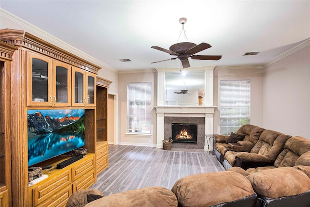 1991 Saint Andrews Dr, Red Oak, TX 75154 - living room featuring ceiling fan, light wood-style floors, ornamental molding, a warm lit fireplace, and baseboards
