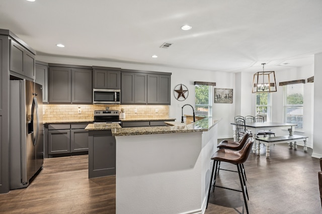 601 S 4th St, Crandall, TX 75114 - kitchen with appliances with stainless steel finishes, decorative backsplash, an island with sink, light stone countertops, and recessed lighting