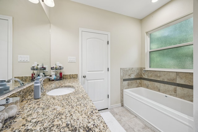 601 S 4th St, Crandall, TX 75114 - bathroom featuring a garden tub, vanity, tile patterned flooring, and baseboards