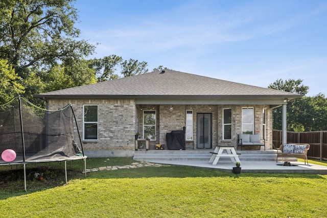 601 S 4th St, Crandall, TX 75114 - back of property with a trampoline, a patio, roof with shingles, and brick siding