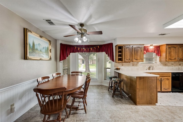 3410 Queenswood Ln, Garland, TX 75040 - dining space featuring healthy amount of natural light, a ceiling fan, a wainscoted wall, and baseboards
