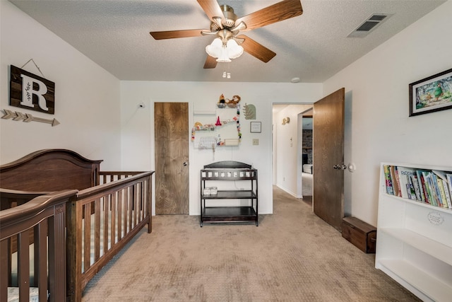 3410 Queenswood Ln, Garland, TX 75040 - bedroom with carpet flooring, a textured ceiling, a nursery area, and ceiling fan