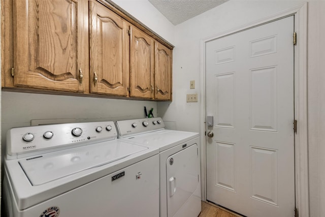 3410 Queenswood Ln, Garland, TX 75040 - laundry room with cabinet space, washing machine and clothes dryer, a textured ceiling, and light wood-style flooring