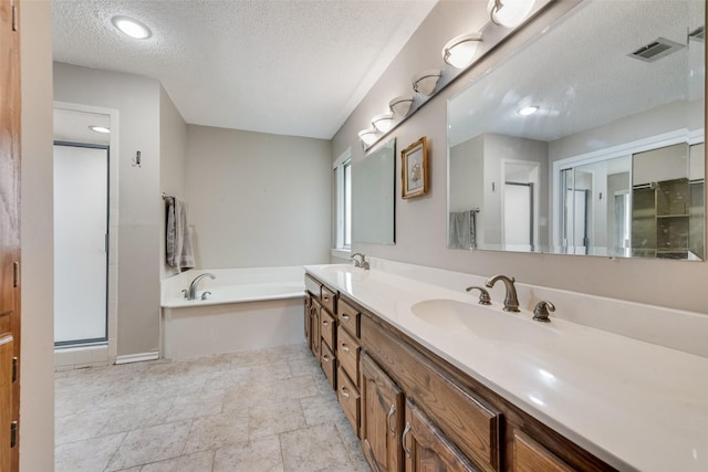 3410 Queenswood Ln, Garland, TX 75040 - full bath featuring a textured ceiling, double vanity, a bath, a shower stall, and baseboards