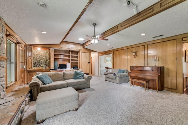 3410 Queenswood Ln, Garland, TX 75040 - living room featuring a textured ceiling, lofted ceiling, a ceiling fan, light colored carpet, and built in shelves