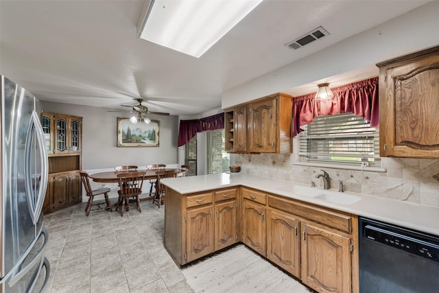 3410 Queenswood Ln, Garland, TX 75040 - kitchen featuring freestanding refrigerator, black dishwasher, a sink, a peninsula, and tasteful backsplash