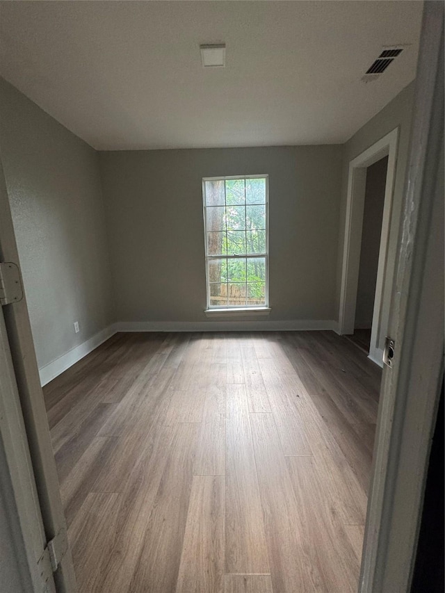 205 W Bond St, Denison, TX 75020 - empty room with wood finished floors and baseboards