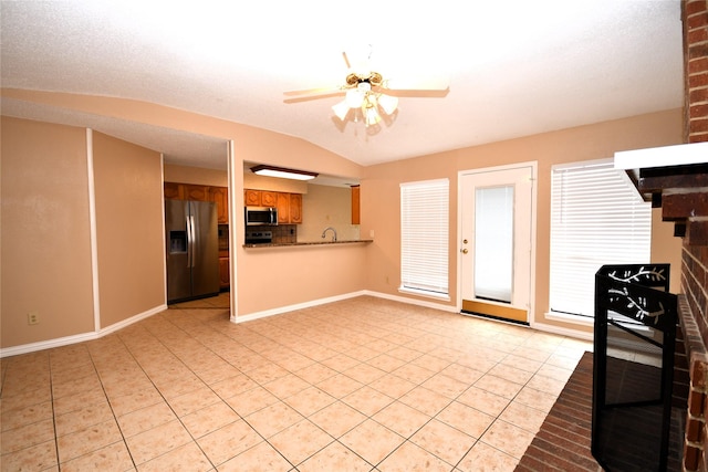 2906 Kingswood Dr, Garland, TX 75040 - kitchen with appliances with stainless steel finishes, light tile patterned flooring, a ceiling fan, baseboards, and lofted ceiling