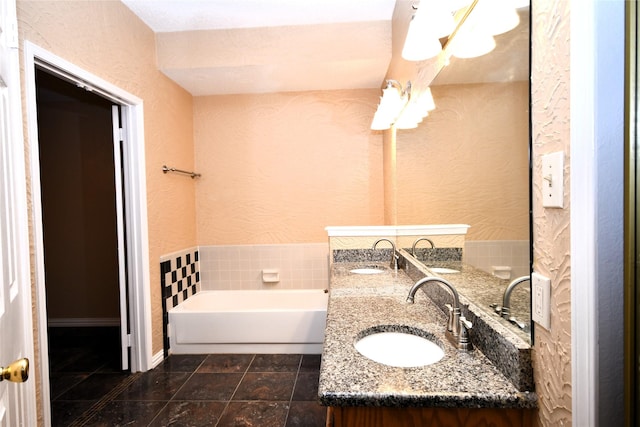 2906 Kingswood Dr, Garland, TX 75040 - full bathroom featuring a textured wall, double vanity, and a bath