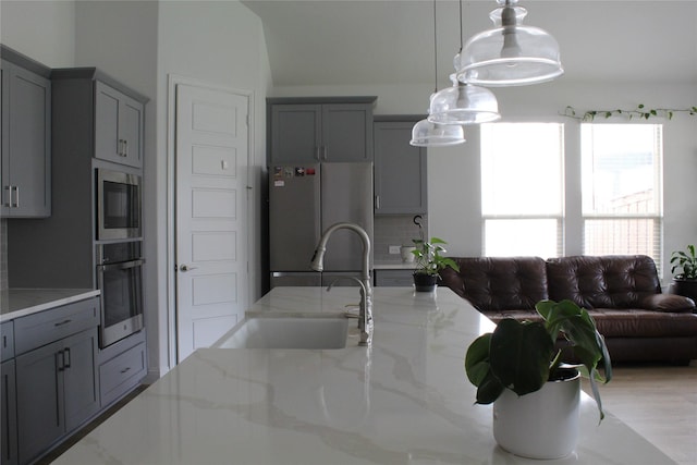 608 Remington Rd, Celina, TX 75009 - kitchen with appliances with stainless steel finishes, gray cabinetry, pendant lighting, and light stone counters