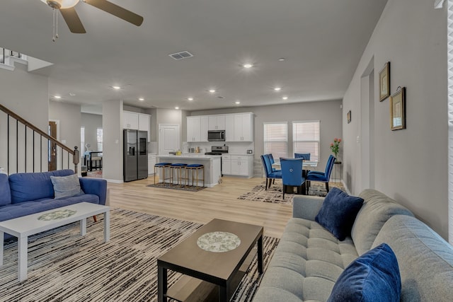 201 Olympus St, Wylie, TX 75098 - living room featuring plenty of natural light, stairs, ceiling fan, light wood-style floors, and recessed lighting