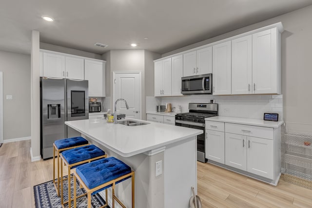 201 Olympus St, Wylie, TX 75098 - kitchen featuring appliances with stainless steel finishes, a sink, white cabinets, light wood-style floors, and recessed lighting