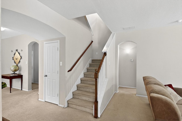 848 Ridge Point Dr, Grand Prairie, TX 75052 - stairway featuring arched walkways, carpet, and a textured ceiling