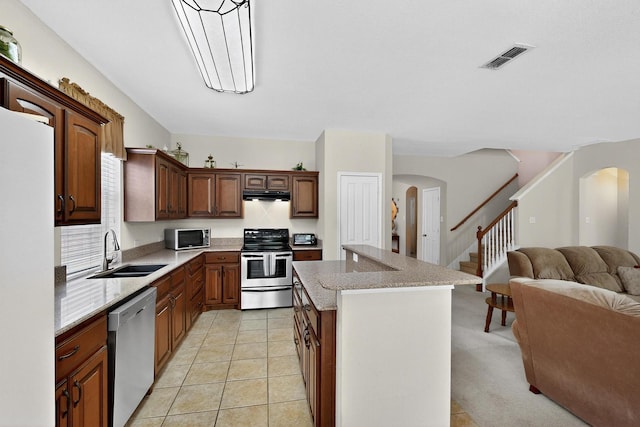 848 Ridge Point Dr, Grand Prairie, TX 75052 - kitchen with stainless steel appliances, arched walkways, under cabinet range hood, and open floor plan