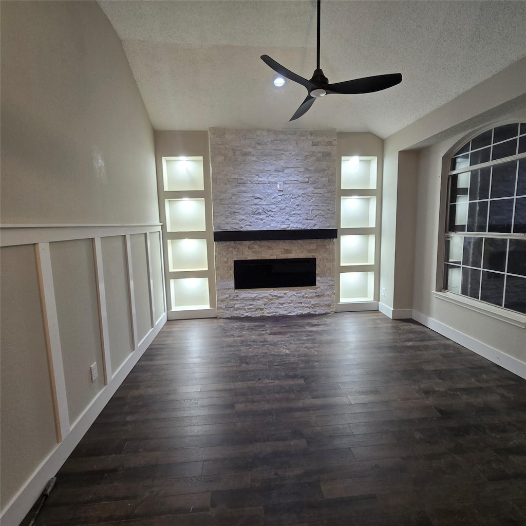 1302 Mill Xing, Garland, TX 75040 - unfurnished living room with built in features, lofted ceiling, a textured ceiling, ceiling fan, and a fireplace