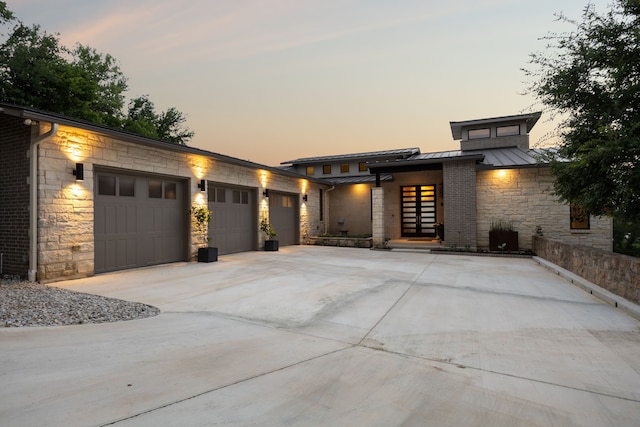 4003 Cheyenne Cir, Flower Mound, TX 75022 - view of front of house with a standing seam roof, stone siding, driveway, a garage, and metal roof