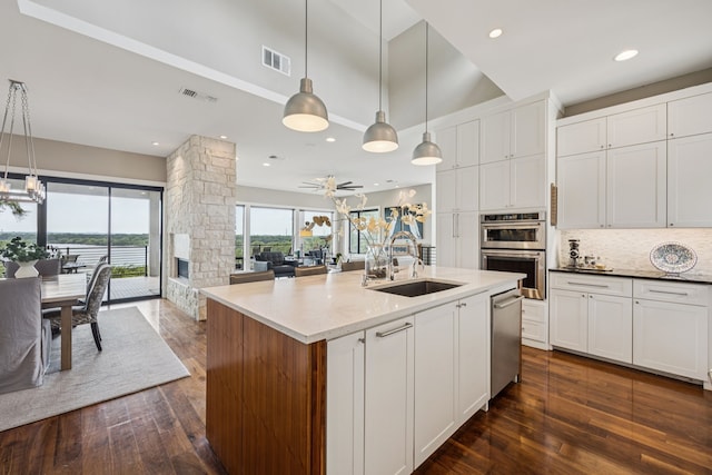 4003 Cheyenne Cir, Flower Mound, TX 75022 - kitchen with a sink, dark wood finished floors, stainless steel appliances, decorative backsplash, and white cabinets