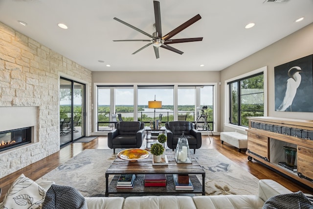4003 Cheyenne Cir, Flower Mound, TX 75022 - living area with a stone fireplace, a ceiling fan, recessed lighting, and wood finished floors